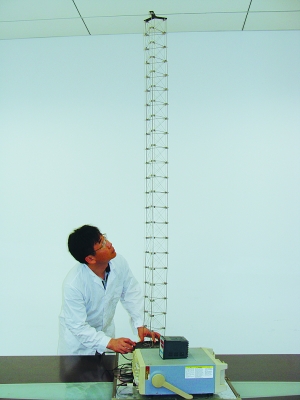 這是伸展開(kāi)的衛星太陽(yáng)能電池用盤(pán)壓伸桿，20厘米長(cháng)螺旋狀的盤(pán)壓伸桿（右側小圖）打開(kāi)后能達2米長(cháng)（8月7日攝）。（新華社發(fā)）
