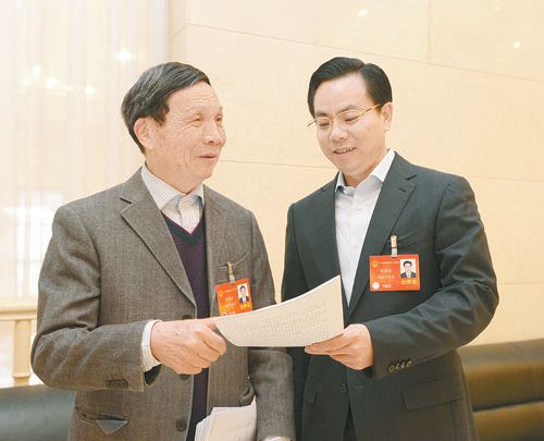 黃伯云代表（左）與劉國忠代表商討完善《關(guān)于建立戰略性新興產(chǎn)業(yè)國家創(chuàng  )新平臺》的建議。 本報記者 張目 攝